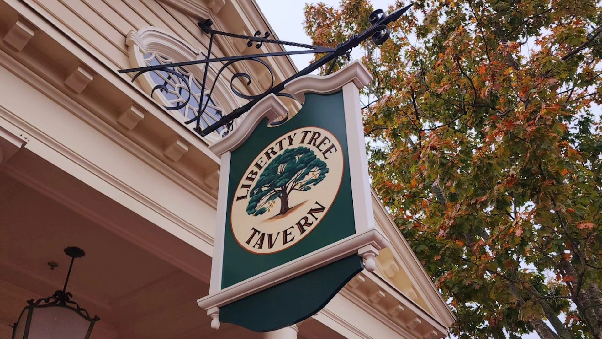 Green and white entrance sign hung on a colonial style building